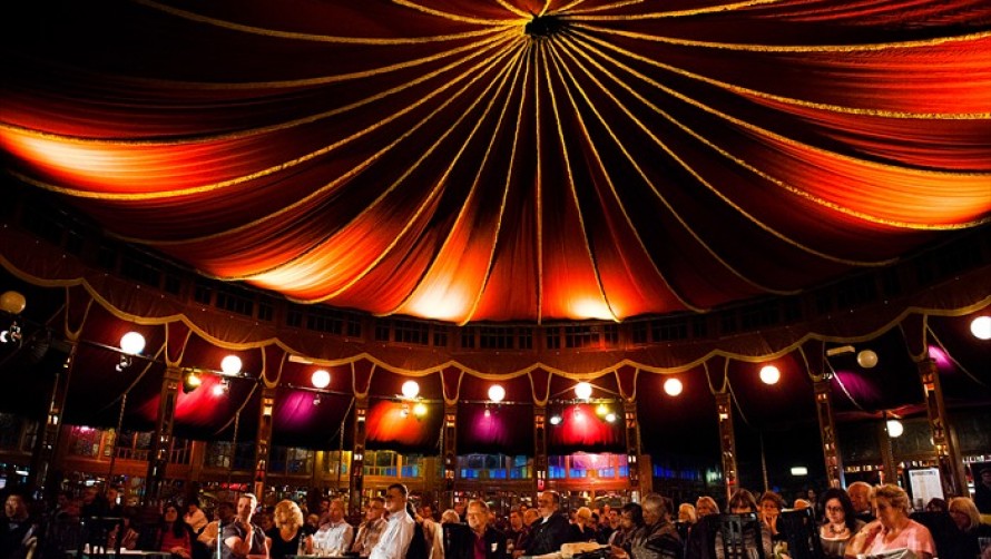 Crowd standing at a bar inside a decorative festival tent - Cheltenham Festival