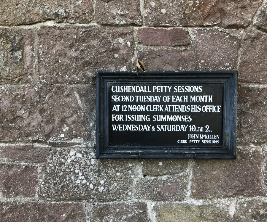 Vintage signage, framed in black wooden frame displayed on a stone wall at Ulster Folk Museum - National Museums of Northern Ireland.
